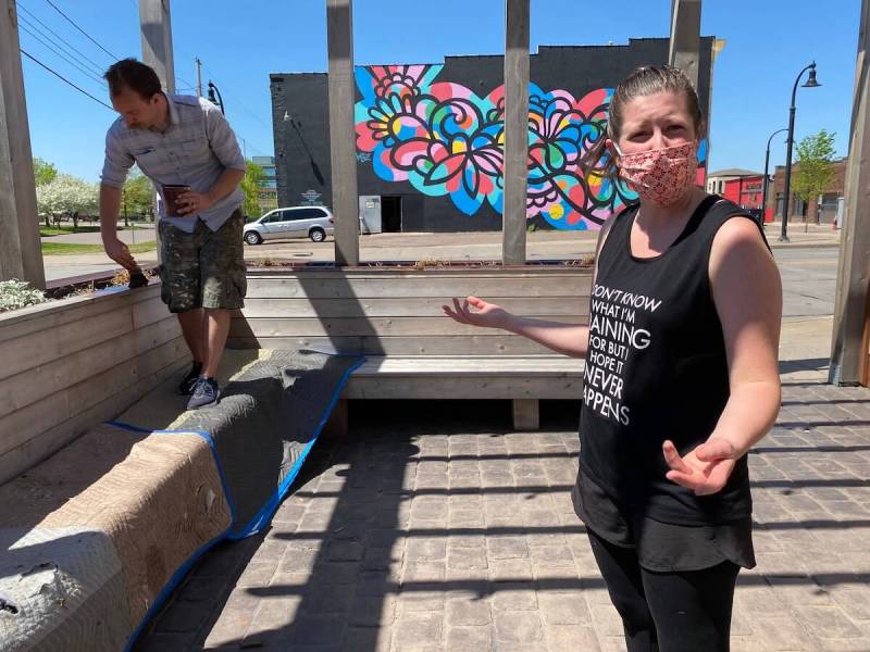 Kayla Midthun, who owns Ramone’s Ice Cream Parlor in downtown Eau Claire with her husband Blayne, discusses efforts they have taken to protect customers and employees from COVID-19 as Blayne applies stain to a deck outside the shop Wednesday.