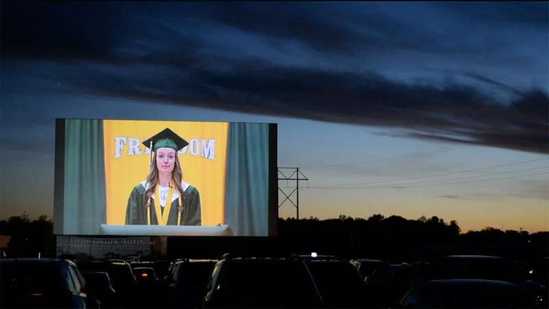 Caps and Gowns and a Great Big Screen as a Wisconsin Class Graduates at a Drive-In