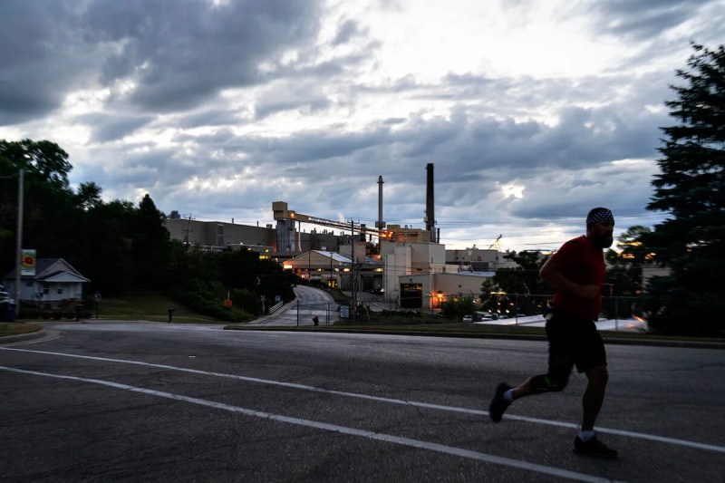 A jogger runs past the Midwest Paper Group mill in Combined Locks