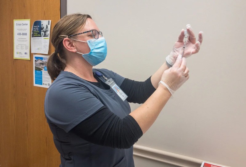 Registered nurse Kay Hartman at N.E.W. Community Clinic in Green Bay prepare to administer second doses of the COVID-19 vaccine to several of the clinic’s medical staff and volunteers on Jan. 27, 2021. (Photo by Christina Lieffring)