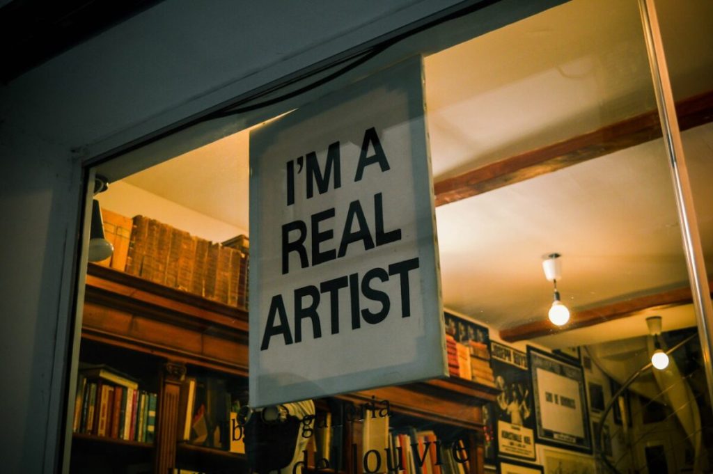 Sign outside of a store that reads "I'm A Real Artist"