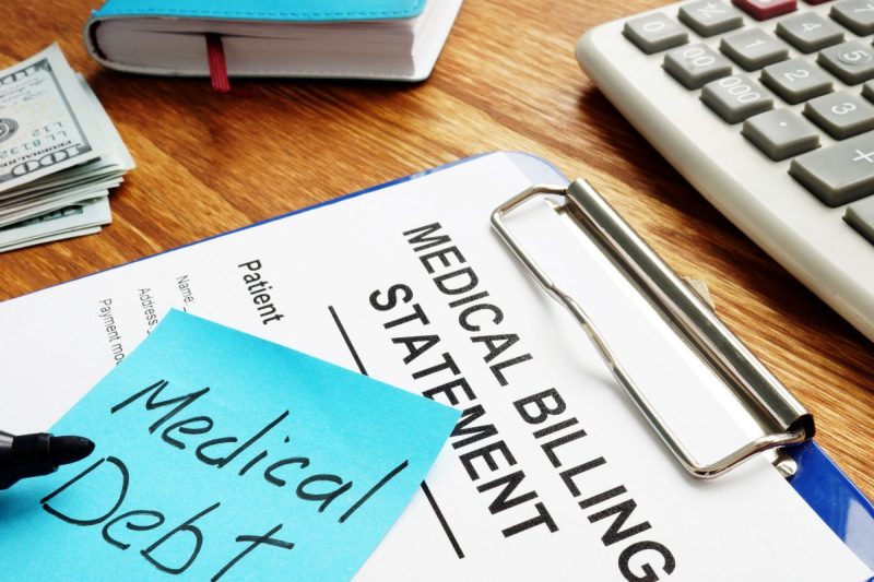 Medical Debt written on sticky note on top of medical billing statement