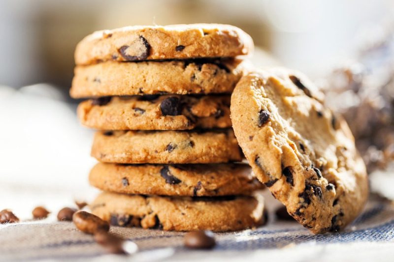 A stack of chocolate chip cookies at a bakery