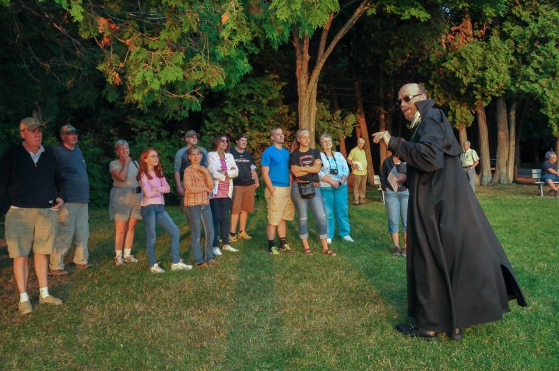 Man leading a ghost tour group.