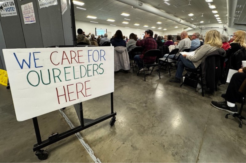 People for Pine Crest Nursing Home town hall sign that reads "we care for ourselves here"