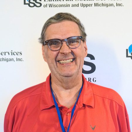 Photo of man wearing glasses in a red shirt.