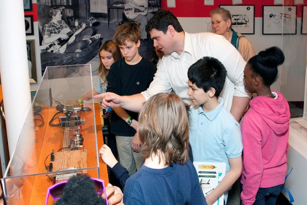 Educator explaining Paul's inventions to children