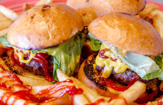 Mini burgers on a paper platter.