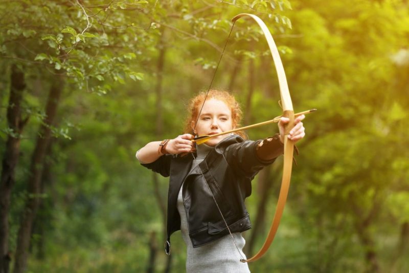 woman drawing back a bow and arrow