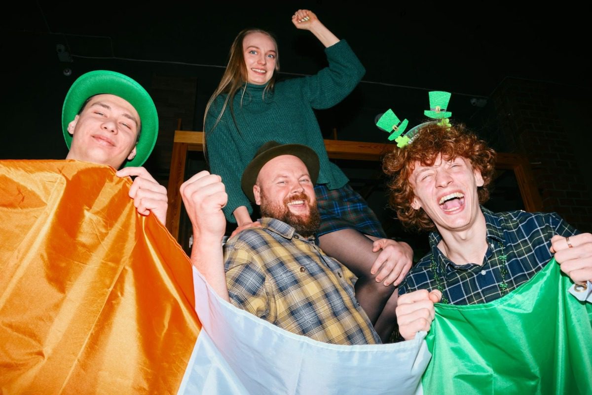 laughing folks holding an irish flag