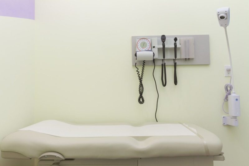 a white doctor's office with a table and equipment