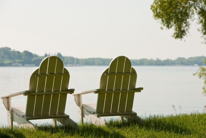 two chairs sit facing the waterfront of lake geneva