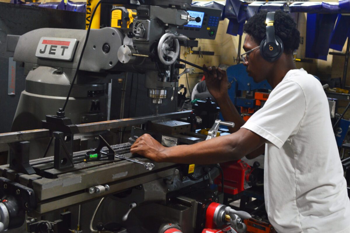 a student uses a metalworking machine in manufacturing class